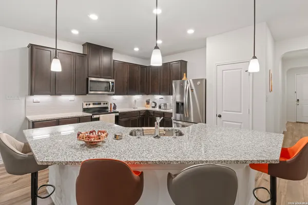 a kitchen with stainless steel appliances granite countertop a sink refrigerator and cabinets