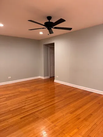 a view of a room with wooden floor and ceiling fan