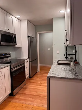 a kitchen with kitchen island granite countertop a stove and a sink