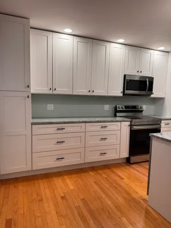 a kitchen with granite countertop a stove a sink and a microwave