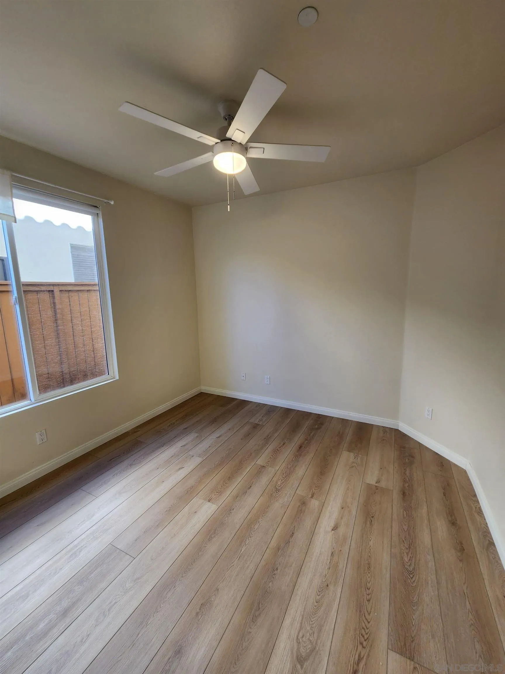 10552 Canberra Court San Diego, CA 92127 - Photo 11 of 25 an empty room with wooden floor and windows