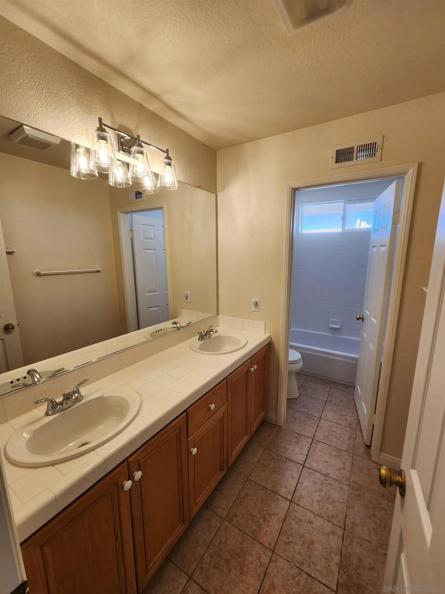 10552 Canberra Court San Diego, CA 92127 - Photo 13 of 25 a bathroom with a double vanity sink a mirror and a bathtub