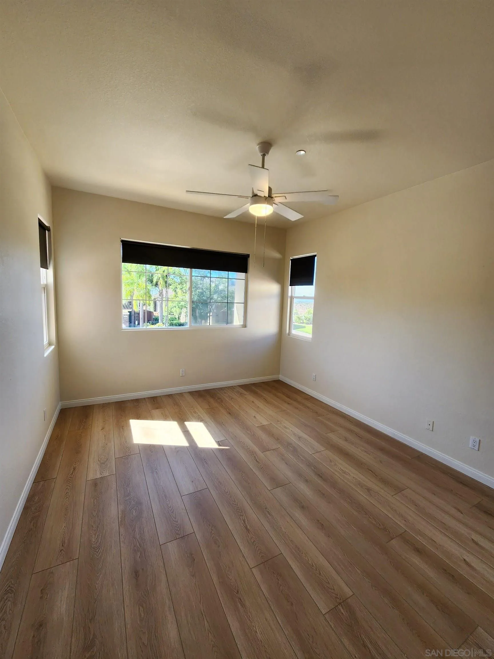 10552 Canberra Court San Diego, CA 92127 - Photo 16 of 25 an empty room with wooden floor and windows