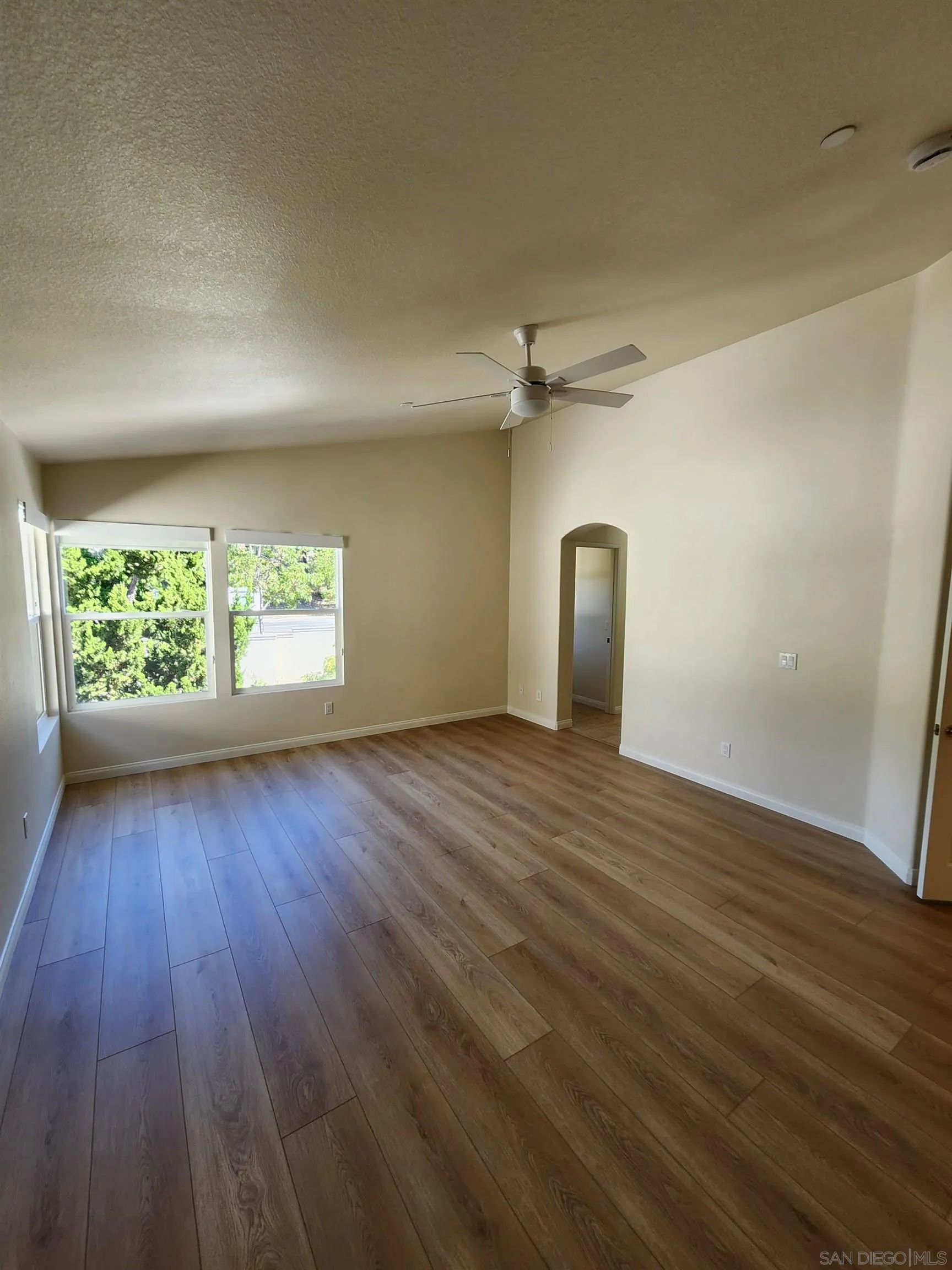 10552 Canberra Court San Diego, CA 92127 - Photo 19 of 25 an empty room with wooden floor mirror and windows