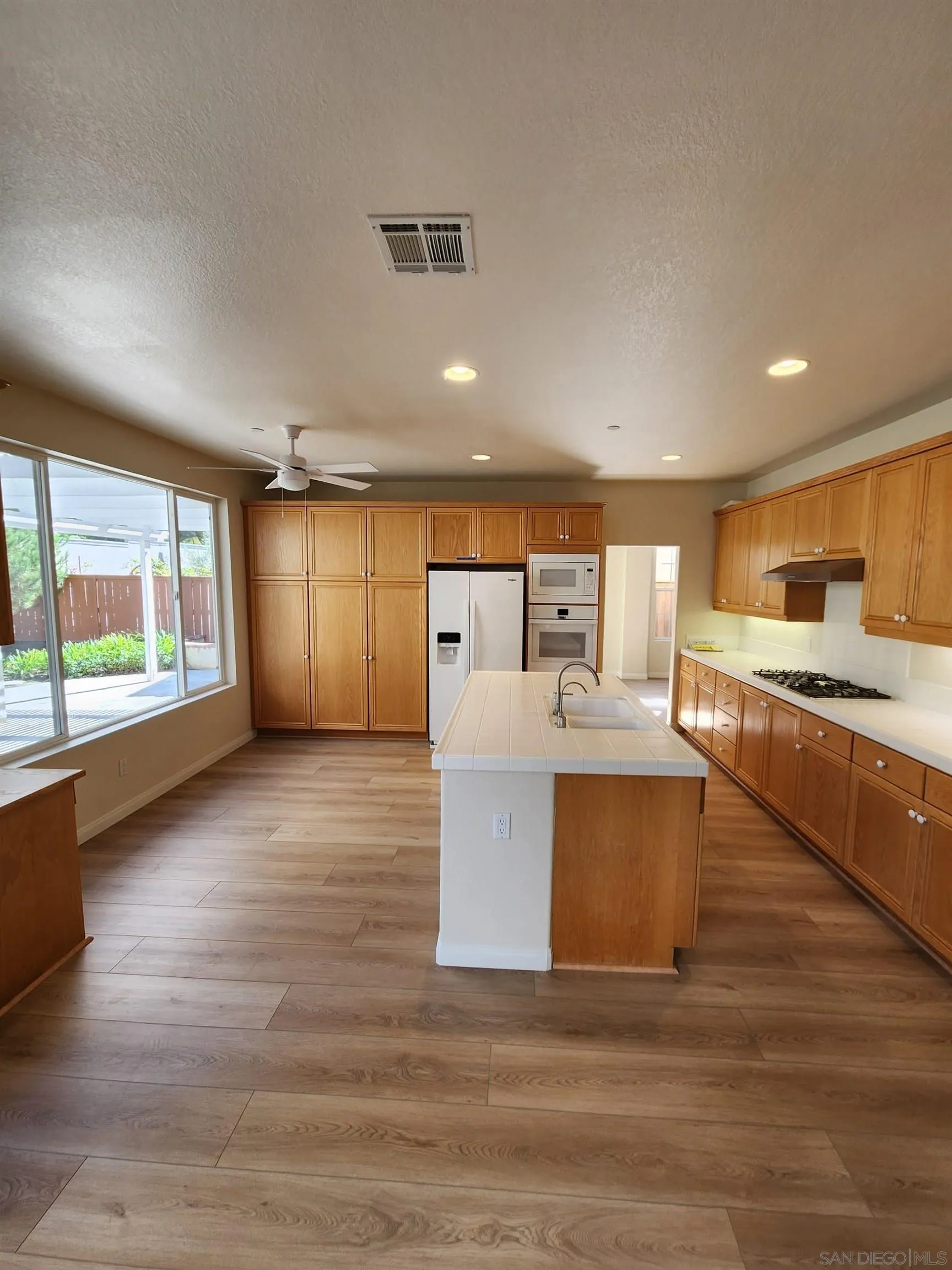 10552 Canberra Court San Diego, CA 92127 - Photo 6 of 25 a large kitchen with stainless steel appliances a large counter top a stove and a refrigerator