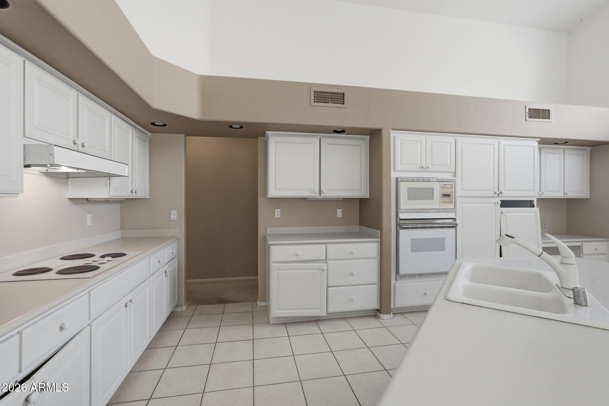 16651 South 18th Way Phoenix, AZ 85048 - Photo 14 of 43 a kitchen with white cabinets and appliances