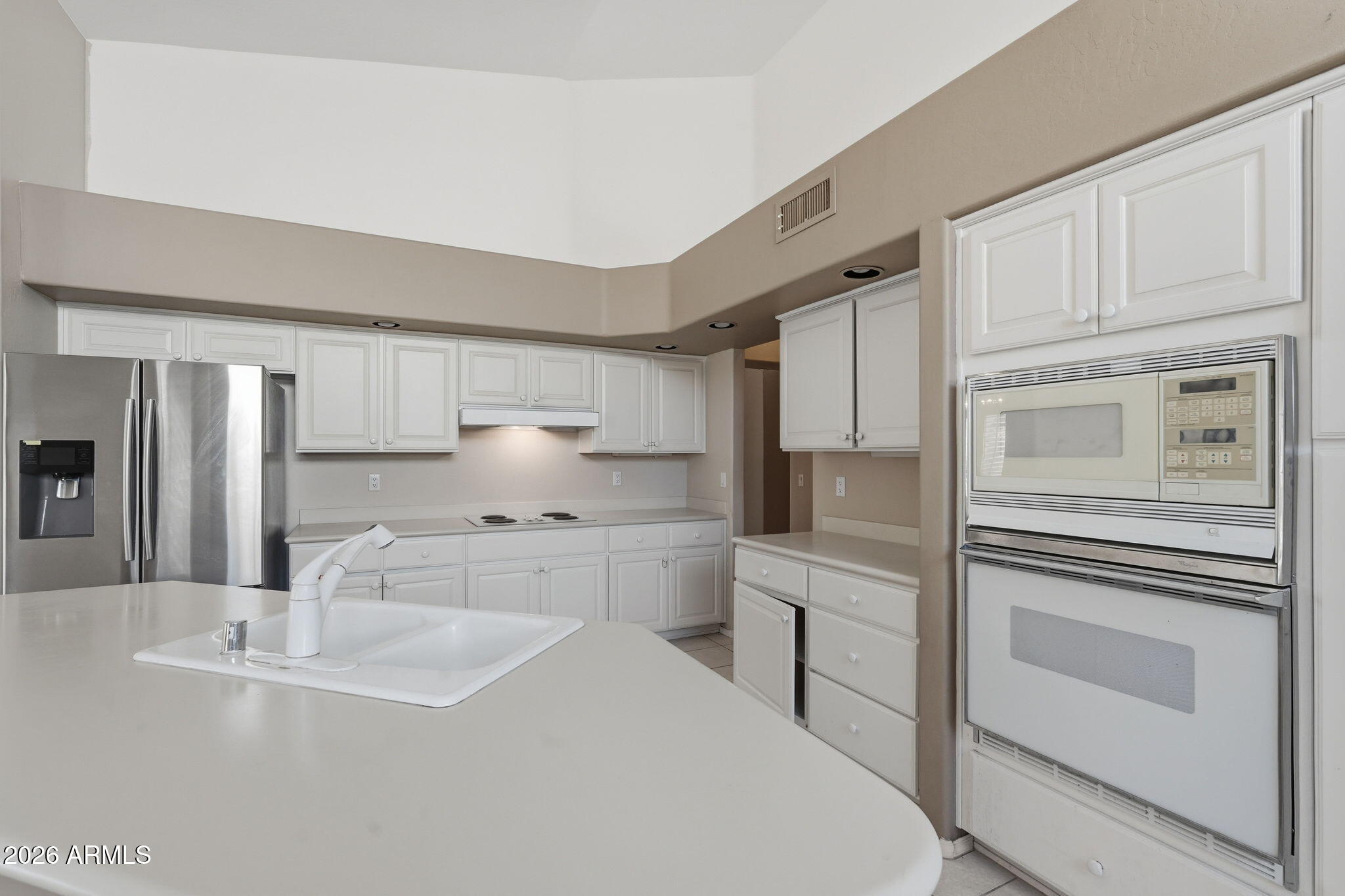 16651 South 18th Way Phoenix, AZ 85048 - Photo 17 of 43 a kitchen with white cabinets and white appliances