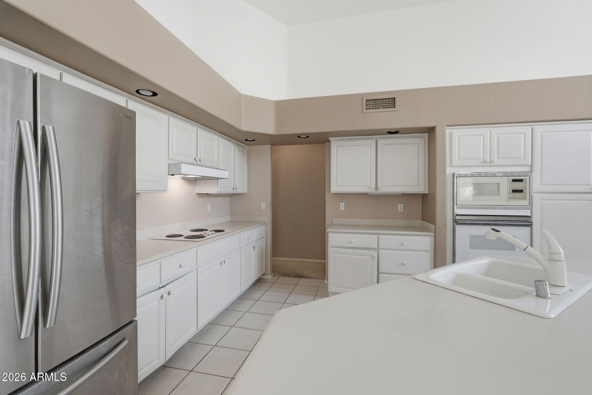 16651 South 18th Way Phoenix, AZ 85048 - Photo 18 of 43 a kitchen with white cabinets and refrigerator