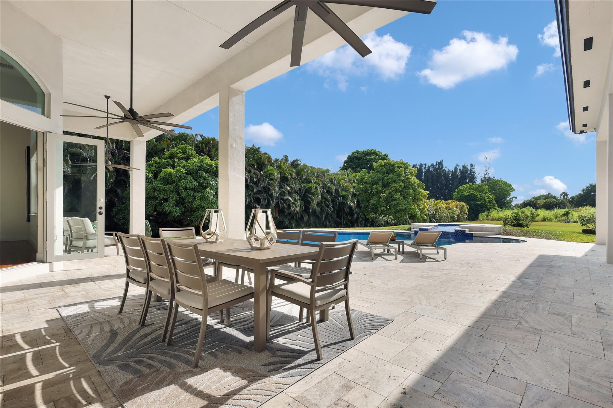 Undisclosed Address Southwest Ranches, FL 33332 - Photo 46 of 54 a view of a patio with a table chairs and a floor to ceiling window