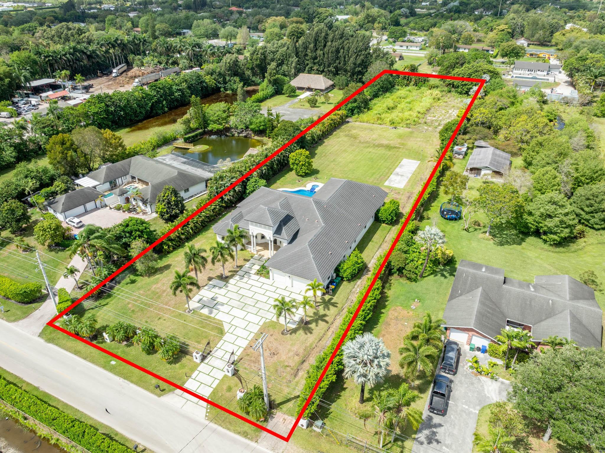 Undisclosed Address Southwest Ranches, FL 33332 - Photo 6 of 54 an aerial view of a residential building with swimming pool and lawn chairs