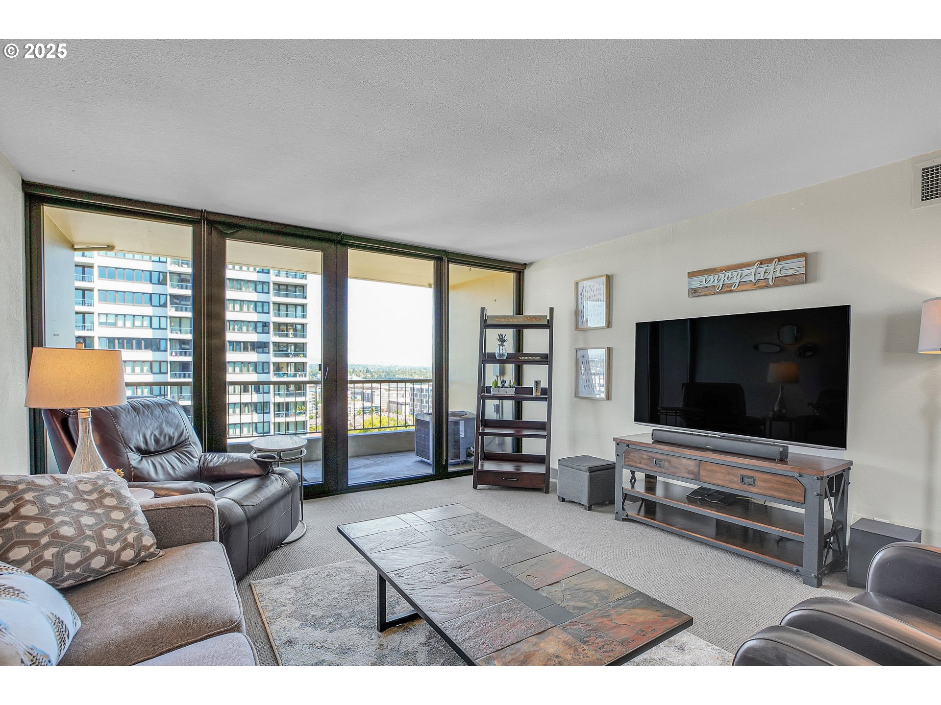 255 Southwest Harrison Street, Unit 17F Portland, OR 97201 - Photo 4 of 31 a living room with furniture and a flat screen tv