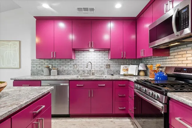 a kitchen with stainless steel appliances a sink dishwasher stove top oven and cabinets