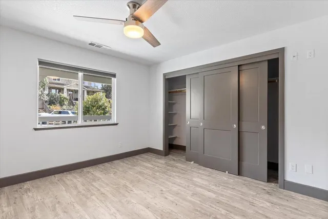 a view of empty room with window and wooden floor