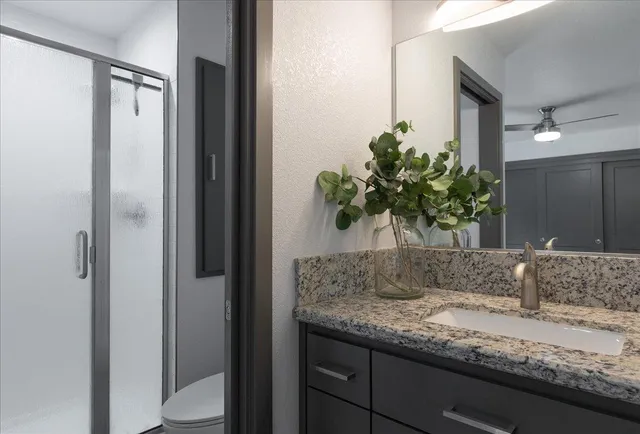 a bathroom with a granite countertop sink and a mirror
