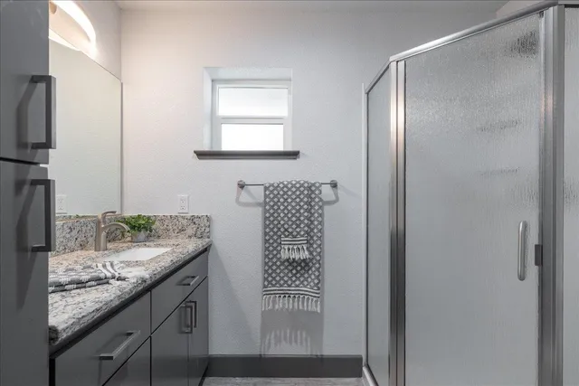 a bathroom with a granite countertop sink and a mirror