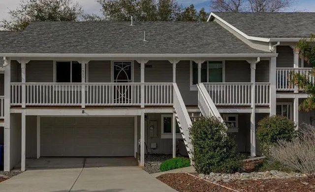 a front view of a house with a tree
