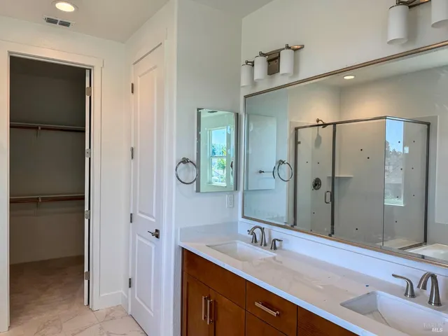 a bathroom with a double vanity sink shower and a mirror
