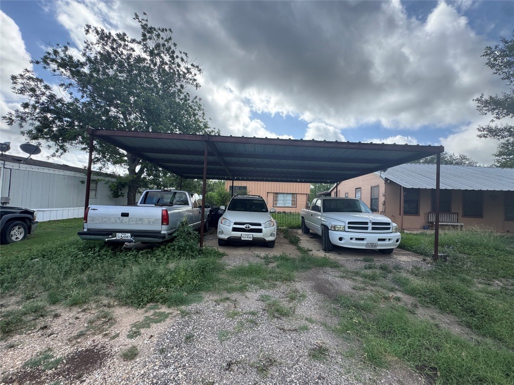 2109 Castro Avenue Hondo, TX 78861 - Photo 6 of 7 a view of a backyard with couple of cars parked