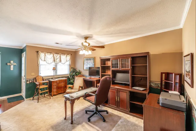 a bedroom with a bed and a large mirror next to a window