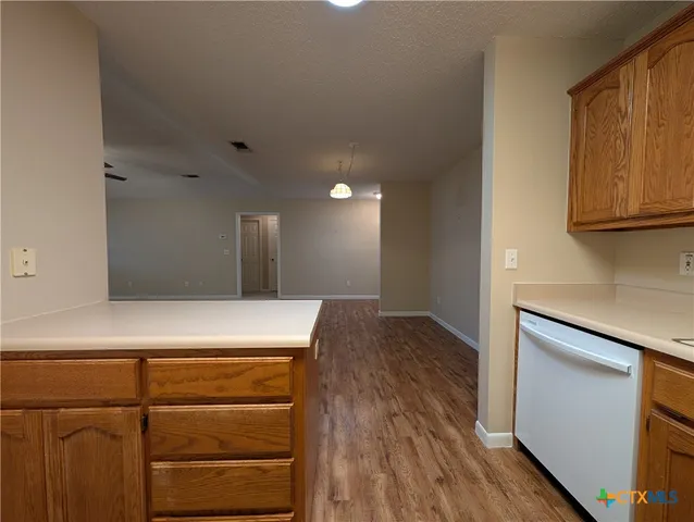 an empty room with windows and ceiling fan