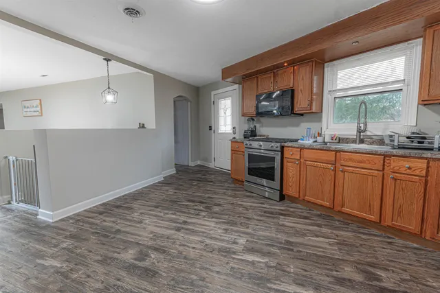 a kitchen with stainless steel appliances granite countertop a stove a sink dishwasher and a refrigerator