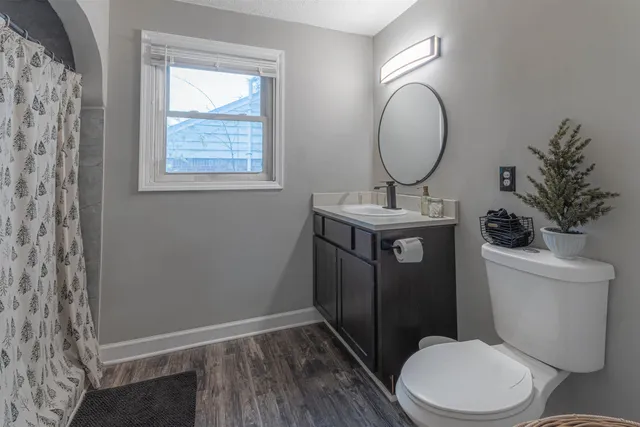 a bathroom with a toilet a sink and mirror