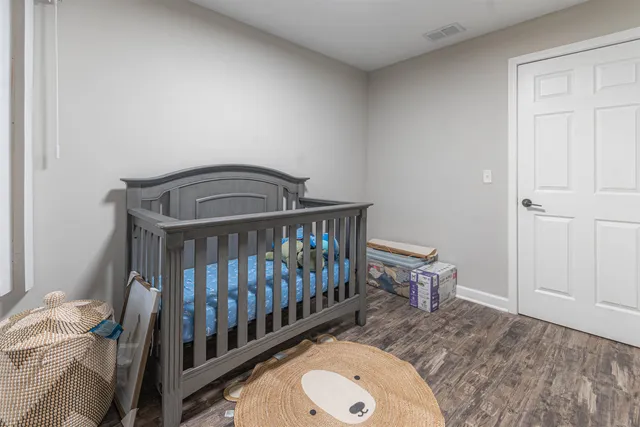 a bedroom with a bed and a wooden floor