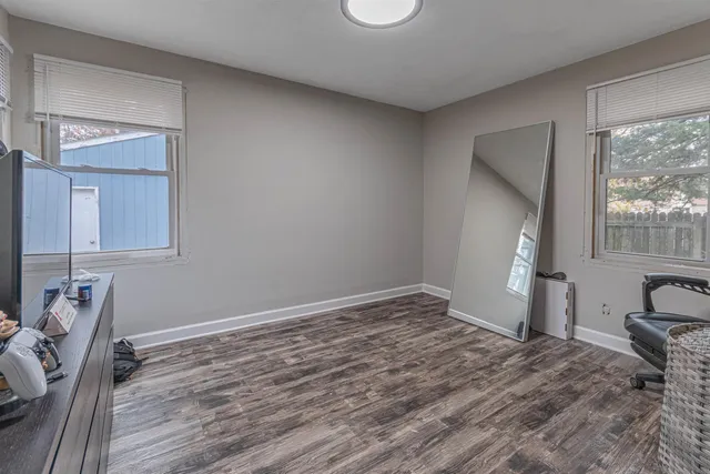 a room with a bed and wooden floor