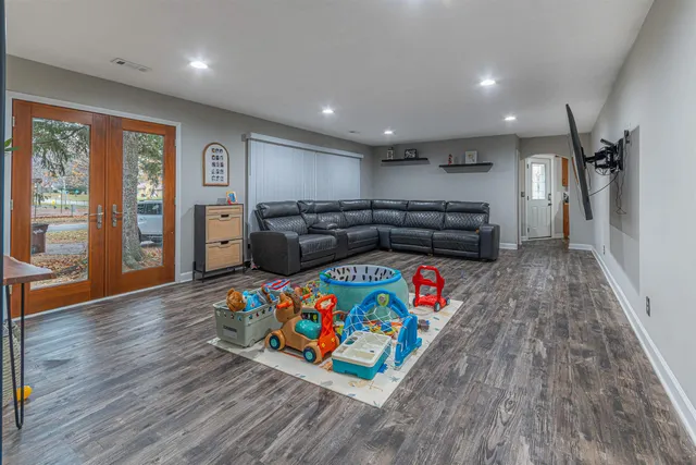 a living room with furniture and a wooden floor