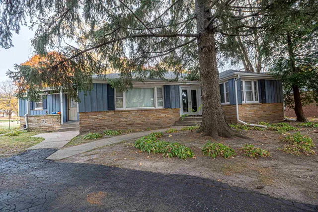 a front view of house with yard and trees around