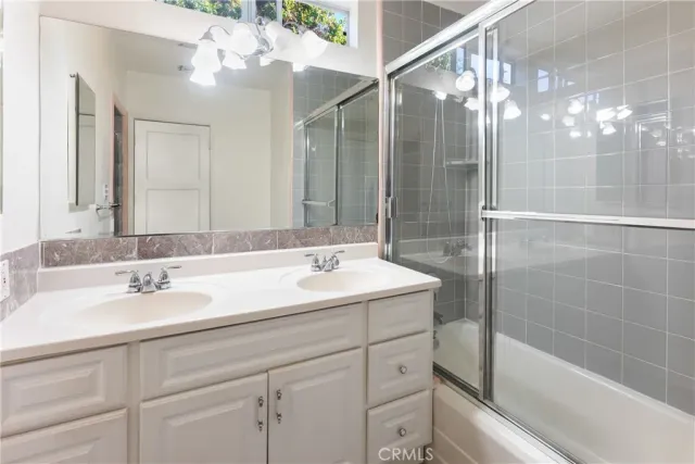 a bathroom with a sink shower and a mirror