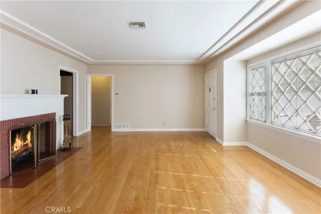 a view of an empty room with window and fire place