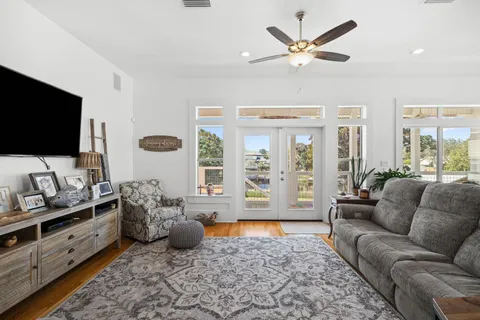 a living room with furniture ceiling fan and a flat screen tv