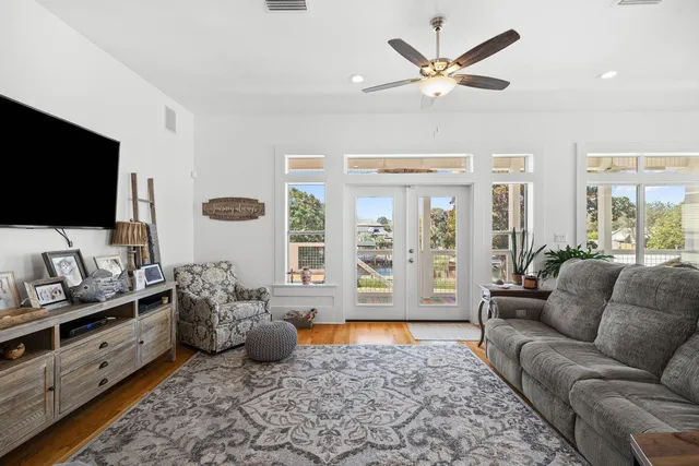 a living room with furniture ceiling fan and a flat screen tv