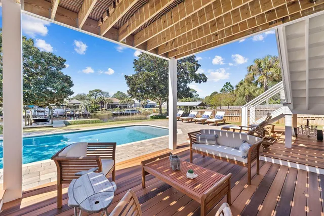 a view of a patio with a dining table and chairs with wooden floor