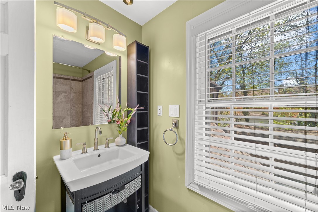 3806 Westwood Road University Heights, OH 44118 - Photo 25 of 41 Bathroom featuring a single vanity with an integrated sink, brushed nickel faucet, wall-mounted mirror, and overhead light fixture