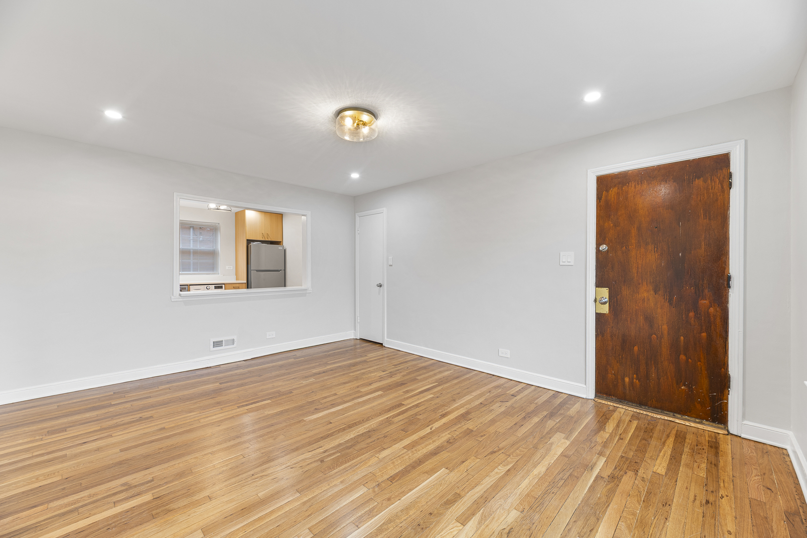 132 Ridge Avenue, Unit 2 Evanston, IL 60202 - Photo 2 of 14 an empty room with wooden floor and windows