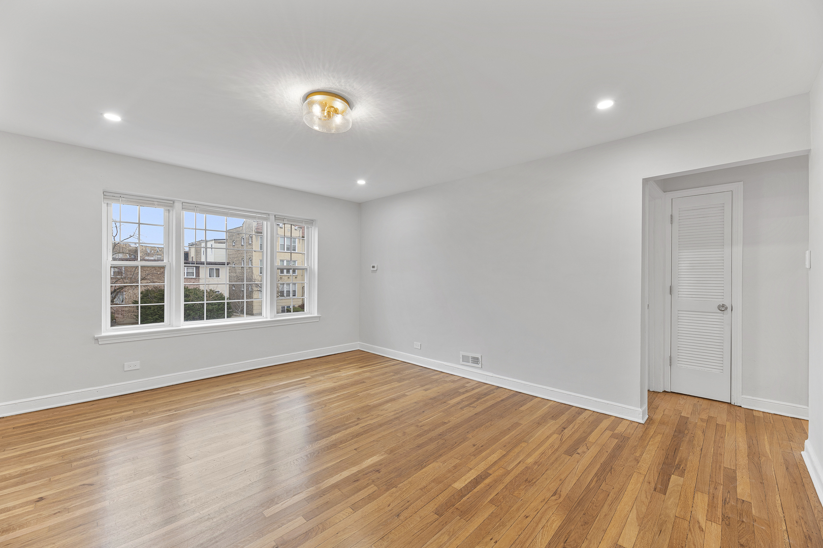 132 Ridge Avenue, Unit 2 Evanston, IL 60202 - Photo 4 of 14 a view of an empty room with wooden floor and a window