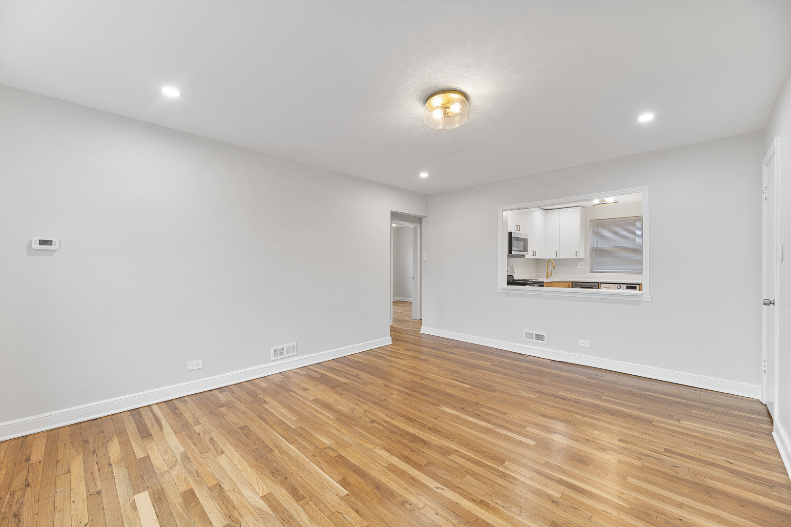 132 Ridge Avenue, Unit 2 Evanston, IL 60202 - Photo 5 of 14 a view of an empty room with wooden floor and a window