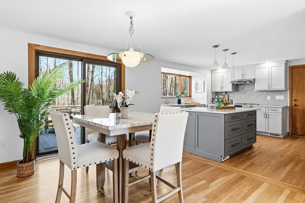 a kitchen with a table chairs and white cabinets