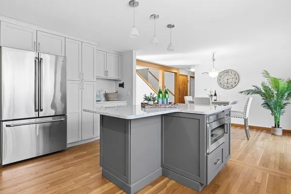a kitchen with kitchen island granite countertop a sink a counter space and stainless steel appliances
