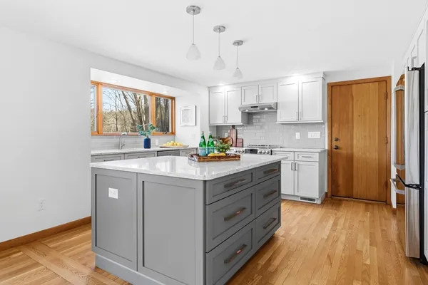a kitchen with stainless steel appliances granite countertop a sink stove and refrigerator