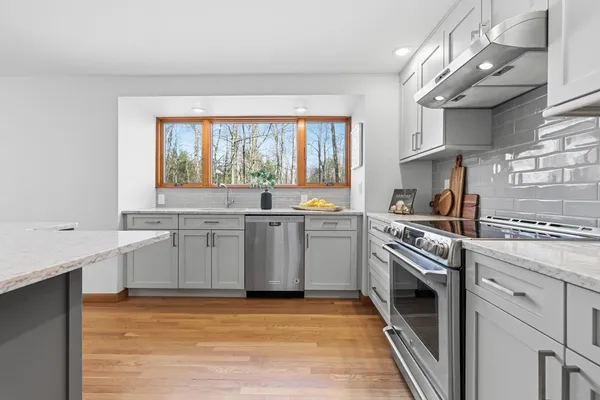 a kitchen with granite countertop a sink a stove a washer and dryer