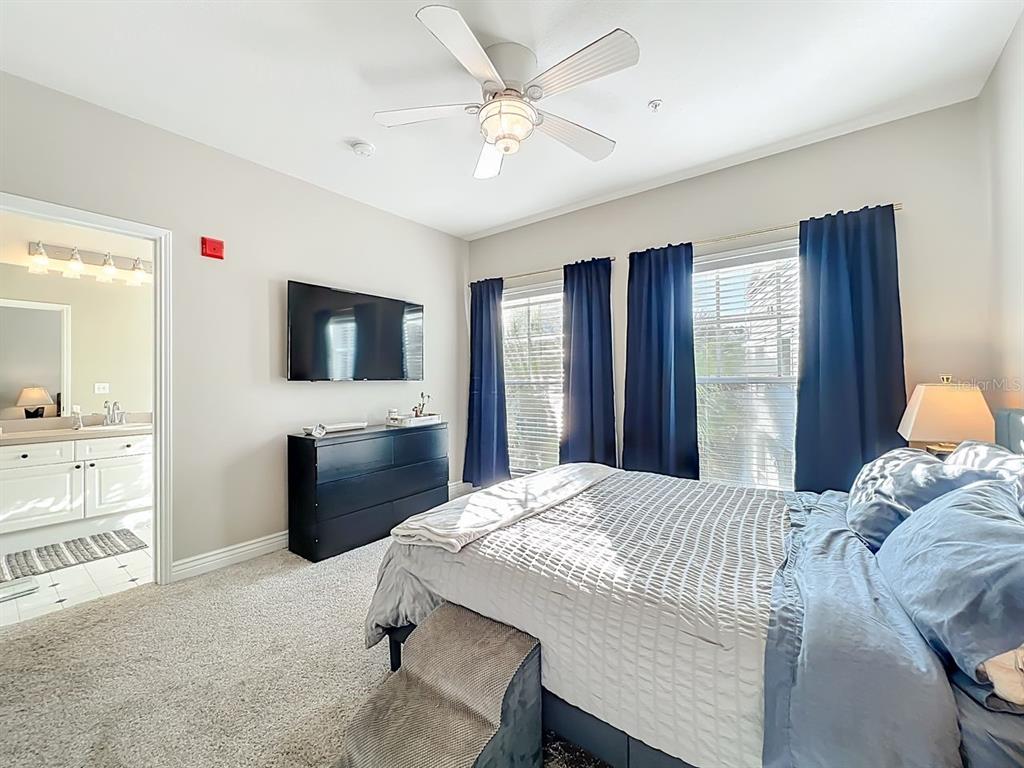 793 Celebration Avenue Celebration, FL 34747 - Photo 17 of 32 a bedroom with a bed and a flat screen tv