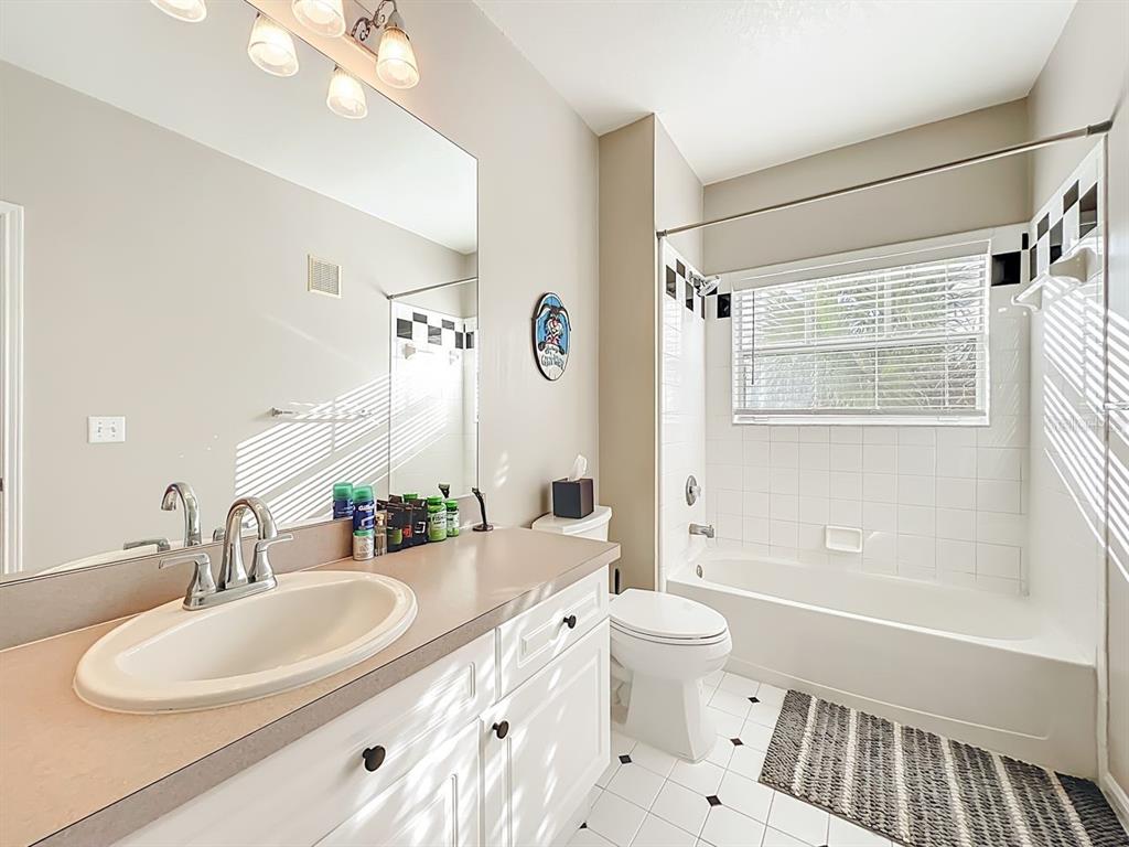 793 Celebration Avenue Celebration, FL 34747 - Photo 20 of 32 a bathroom with a double vanity sink toilet mirror and shower