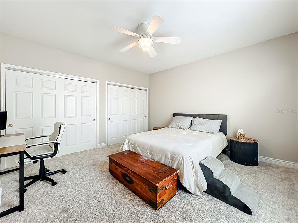 793 Celebration Avenue Celebration, FL 34747 - Photo 21 of 32 a bedroom with a bed a chair and a potted plant