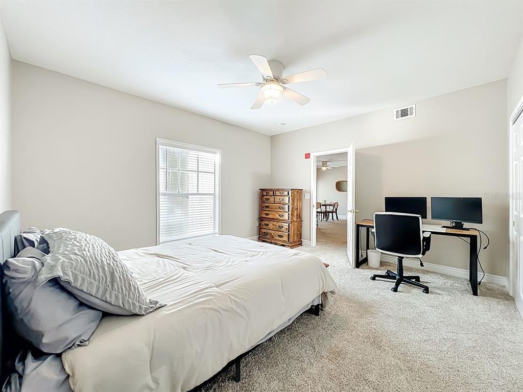 793 Celebration Avenue Celebration, FL 34747 - Photo 22 of 32 a bedroom with a bed a chair and bed