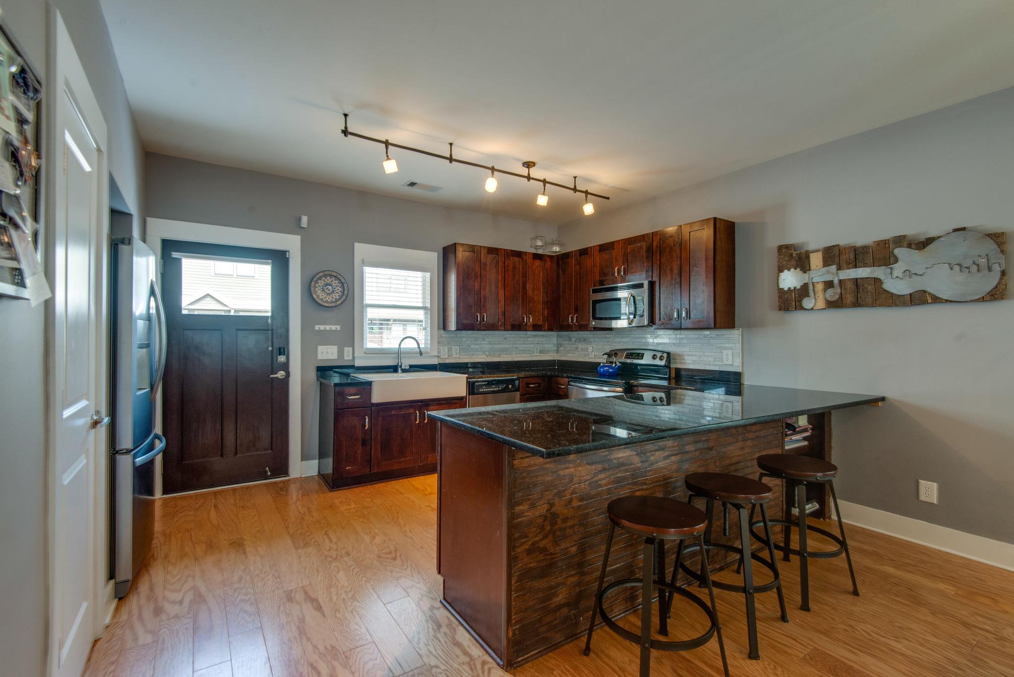 205 Copley Lane Nashville, TN 37204 - Photo 6 of 20 a kitchen with stainless steel appliances granite countertop a sink stove and wooden floor