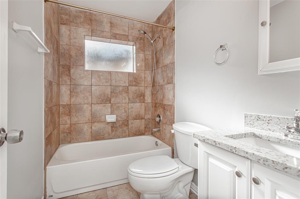 4931 Junius Street, Unit 4 Dallas, TX 75214 - Photo 18 of 31 a bathroom with a granite countertop sink a toilet and shower