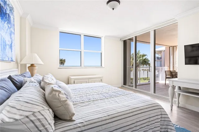 a bedroom with a large bed and a flat tv screen
